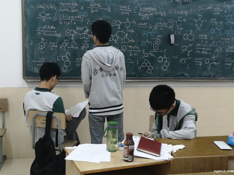江乐岩同学和队友一起研究化学竞赛.jpg